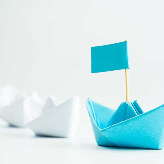 Symbolbild Führung: Ein Boot leitet andere
